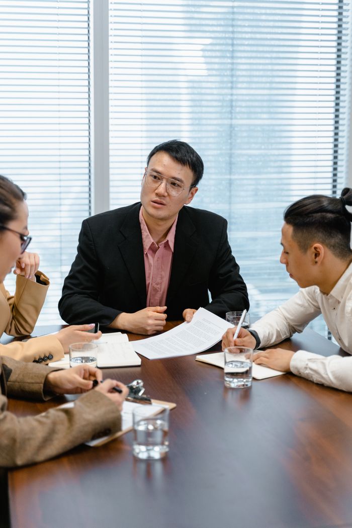 about-us-02 Team of professionals collaborating during a business meeting in a modern office setting.