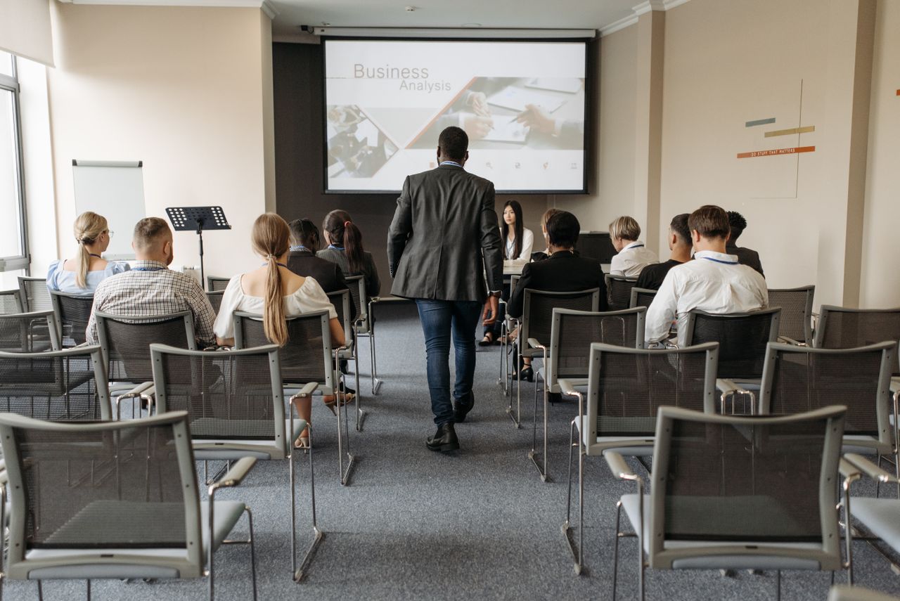 The Art of Drawing Readers In: Your attractive post title goes here Business conference setting with diverse participants focusing on analysis presentation.